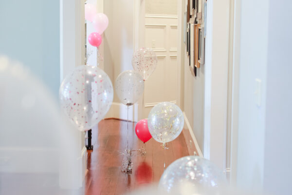 Balloons laid out in a hallway to create a DIY birthday surprise ideas