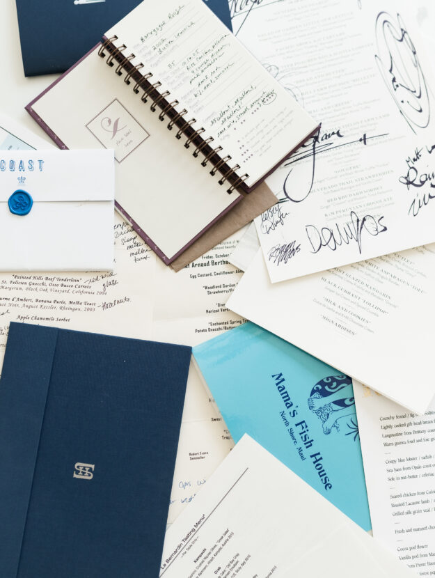 A collection of restaurant menus laid out on a table asa way to demonstrate saving restaurant menus as keepsakes.