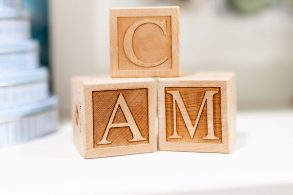 A baby birth detail keepsake stack of 3 wood baby blocks that are personalized with the initials C, A and M.